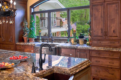 Inspiration for a mid-sized mediterranean galley porcelain tile and white floor eat-in kitchen remodel in Chicago with a farmhouse sink, raised-panel cabinets, dark wood cabinets, granite countertops and an island