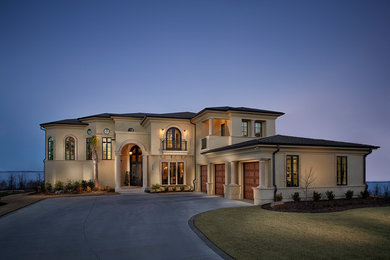 Example of a huge transitional beige two-story stucco house exterior design in Charleston with a hip roof and a shingle roof