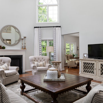 Neutral Two Story Family Room with Tufted Wing Chairs