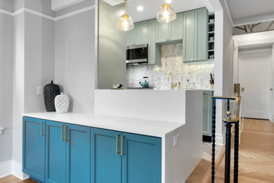 Mid-sized transitional galley medium tone wood floor eat-in kitchen photo in New York with a drop-in sink, beaded inset cabinets, green cabinets, quartz countertops, multicolored backsplash, marble backsplash, stainless steel appliances, an island and white countertops