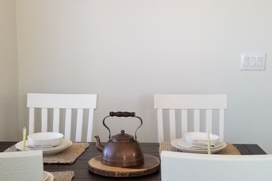 Imagen de comedor de cocina rústico con paredes blancas y suelo vinílico