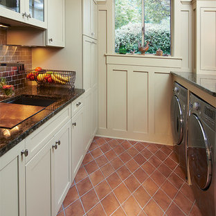 Medium sized traditional galley utility room in Cleveland with recessed-panel cabinets, beige cabinets, white walls, ceramic flooring, a side by side washer and dryer, granite worktops and orange floors.
