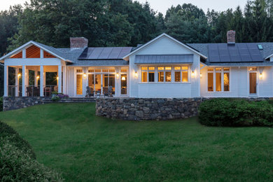 Photo of an expansive transitional one-storey white house exterior with wood siding, a gable roof and a shingle roof.