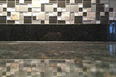 Large transitional l-shaped light wood floor eat-in kitchen photo in Other with an undermount sink, recessed-panel cabinets, white cabinets, granite countertops, multicolored backsplash, glass tile backsplash, stainless steel appliances and an island