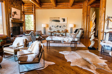 Living room - huge rustic open concept medium tone wood floor, brown floor, exposed beam and wood wall living room idea in Other with white walls, a standard fireplace and a stone fireplace