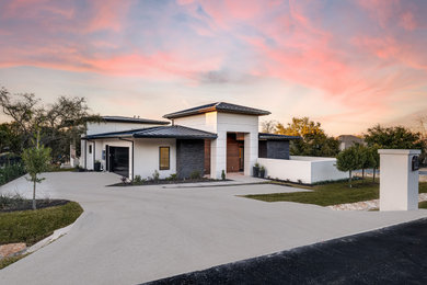 Example of a large multicolored one-story stucco house exterior design in Austin with a hip roof, a metal roof and a gray roof