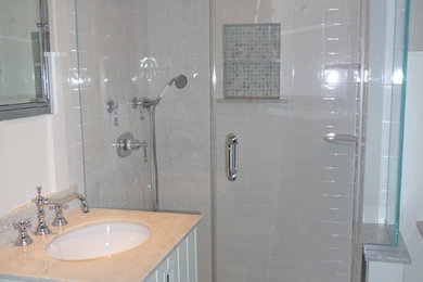Transitional white tile and subway tile bathroom photo in New York with an undermount sink, shaker cabinets, white cabinets, marble countertops and a two-piece toilet
