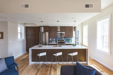 Example of a small mid-century modern single-wall light wood floor and brown floor eat-in kitchen design in Cincinnati with flat-panel cabinets, dark wood cabinets, laminate countertops, blue backsplash, glass tile backsplash, stainless steel appliances, an island and an undermount sink