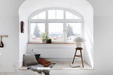 Foto på ett mellanstort skandinaviskt allrum med öppen planlösning, med vita väggar, ljust trägolv och vitt golv