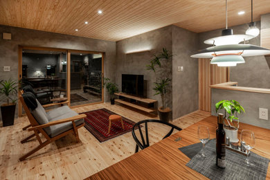 Diseño de salón minimalista con paredes grises, suelo de madera clara, televisor independiente y madera