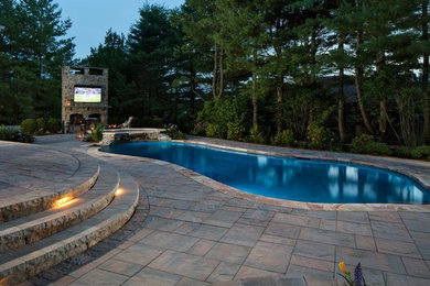Large traditional backyard custom-shaped natural pool in New York with a hot tub and concrete pavers.
