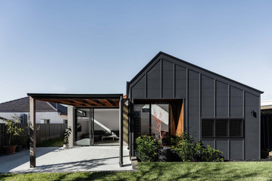 Design ideas for a mid-sized modern one-storey multi-coloured house exterior in Sydney with concrete fiberboard siding, a gable roof, a metal roof, a grey roof and board and batten siding.