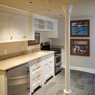 Ejemplo de sótano con puerta tradicional, grande, con paredes beige y suelo de pizarra