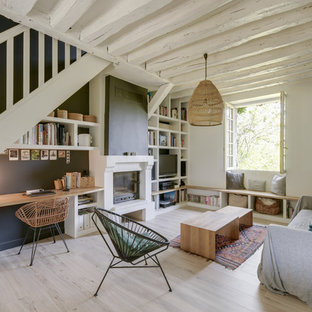 Mittelgroße, Offene Mediterrane Bibliothek mit schwarzer Wandfarbe, Laminat, Kamin, Kaminsims aus Backstein, freistehendem TV und beigem Boden in Paris