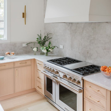 Refined Natural Kitchen with Custom Range Wall and Stone Backsplash