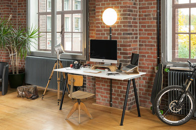 Industrial Arbeitszimmer mit Arbeitsplatz, freistehendem Schreibtisch, roter Wandfarbe und hellem Holzboden in Essen