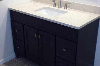 Mid-sized minimalist beige tile and porcelain tile porcelain tile tub/shower combo photo in Other with blue cabinets, a one-piece toilet, beige walls and an integrated sink