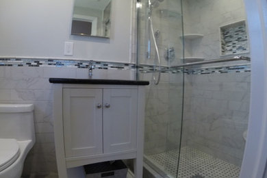 Alcove shower - small modern master white tile and porcelain tile porcelain tile alcove shower idea in New York with an undermount sink, flat-panel cabinets, white cabinets, granite countertops, a one-piece toilet and gray walls