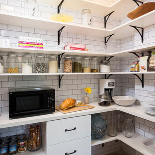 Klassische Küche mit Küchenrückwand in Weiß, Rückwand aus Metrofliesen, schwarzen Elektrogeräten und Vorratsschrank in Los Angeles