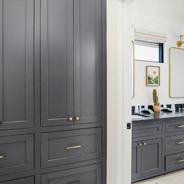 Matching black cabinetry continues into a Jack-and-Jill bathroom with dual vanit