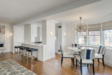 Example of an eclectic medium tone wood floor great room design in New York with white walls