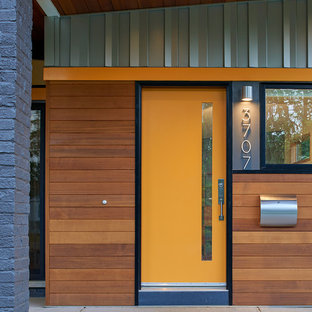 На фото: входная дверь среднего размера в стиле ретро с одностворчатой входной дверью и оранжевой входной дверью с