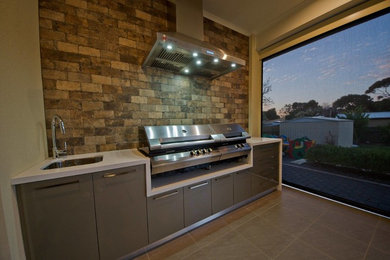 Modern backyard deck in Adelaide with an outdoor kitchen.