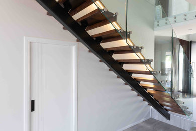 Diseño de escalera suspendida moderna de tamaño medio sin contrahuella con escalones de madera y barandilla de madera