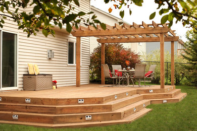 Deck - mid-sized backyard deck idea in Minneapolis with a pergola