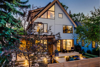 Large trendy white three-story mixed siding gable roof photo in Calgary