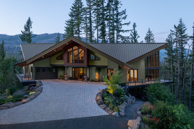 Inspiration for a huge craftsman green two-story concrete fiberboard and clapboard house exterior remodel in Portland with a butterfly roof, a metal roof and a brown roof