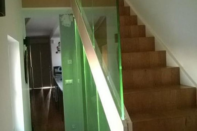 Aménagement d'un escalier droit moderne de taille moyenne avec des marches en bois, des contremarches en bois et un garde-corps en verre.
