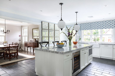 Photo of a mid-sized country u-shaped eat-in kitchen in New York with a farmhouse sink, recessed-panel cabinets, white cabinets, granite benchtops, stainless steel appliances, slate floors and with island.