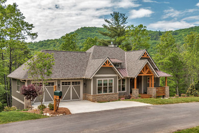 Example of a mountain style gray one-story concrete house exterior design in Other with a hip roof and a mixed material roof