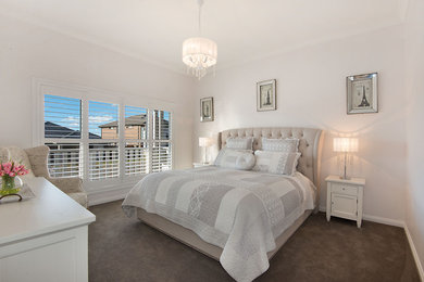 Design ideas for a beach style master bedroom in Sydney with beige walls and carpet.