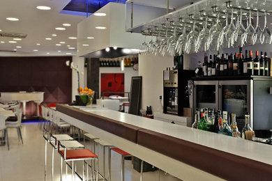 Ispirazione per un grande bancone bar minimalista con pavimento in gres porcellanato, pavimento bianco e top bianco
