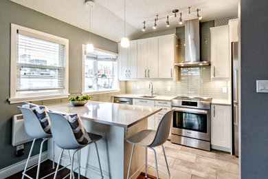 Eat-in kitchen - small transitional galley porcelain tile eat-in kitchen idea in Vancouver with an undermount sink, shaker cabinets, white cabinets, quartz countertops, white backsplash, glass tile backsplash, stainless steel appliances and a peninsula