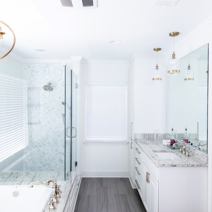Vanity with white cabinets and honey bronze hardware. Frameless mirror above vanity. Glass pendant light with antique copper accents. Frameless shower door. Space Planning by Ourso Designs. Photo by C