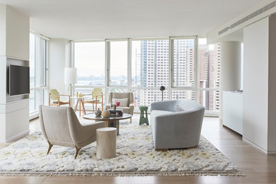 Living room - contemporary light wood floor and beige floor living room idea in New York with white walls and a wall-mounted tv