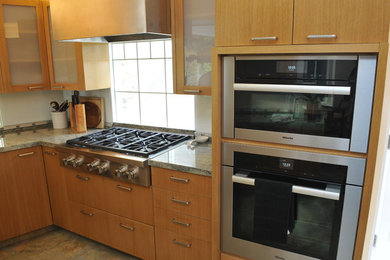 Small elegant l-shaped ceramic tile eat-in kitchen photo in Los Angeles with a single-bowl sink, glass-front cabinets, medium tone wood cabinets, granite countertops, gray backsplash, glass tile backsplash, stainless steel appliances and no island