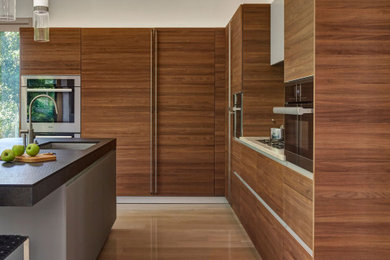 This is an example of a contemporary kitchen in Chicago with flat-panel cabinets, medium wood cabinets, granite benchtops and with island.