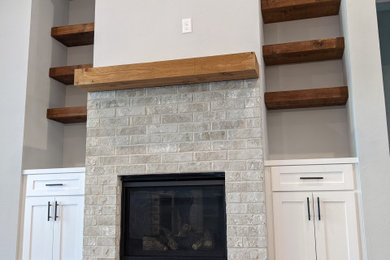 Example of a mid-sized country open concept vinyl floor, gray floor and vaulted ceiling family room design in Dallas with gray walls, a standard fireplace and a brick fireplace