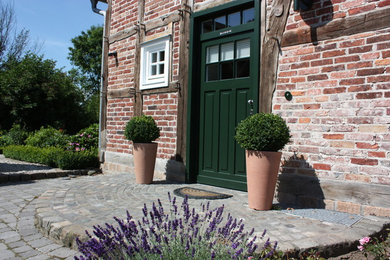 Mittelgroßer, Halbschattiger Landhausstil Vorgarten im Sommer mit Kübelpflanzen und Natursteinplatten in Sonstige