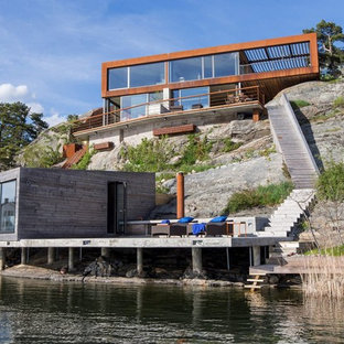 バルセロナのモダンスタイルのおしゃれな家の外観 (木材サイディング、茶色い外壁、陸屋根) の写真