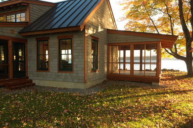 Design ideas for a country one-storey exterior in Burlington with wood siding, a metal roof and a black roof.