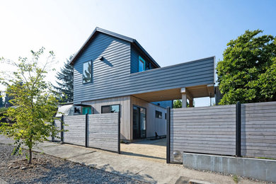 Small trendy gray two-story concrete fiberboard and clapboard exterior home photo in Portland with a shingle roof and a black roof