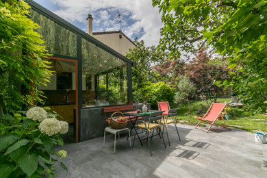 Réalisation d'un jardin potager et terrasse champêtre de taille moyenne avec une cour, des pavés en pierre naturelle et une extension de toiture.