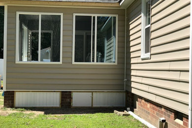 Example of a classic beige one-story house exterior design in Richmond