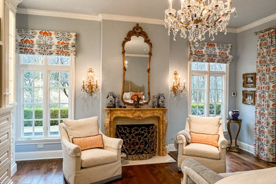 ダラスにある広いトラディショナルスタイルのおしゃれな主寝室 (青い壁、無垢フローリング、標準型暖炉、石材の暖炉まわり、茶色い床)