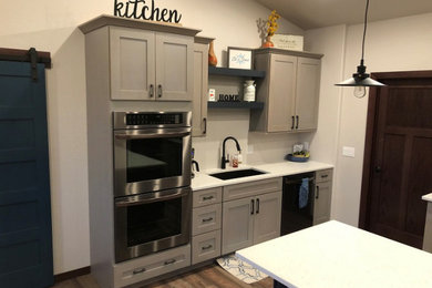 Transitional vinyl floor kitchen photo in Other with shaker cabinets, gray cabinets, quartz countertops, stainless steel appliances, an island and white countertops